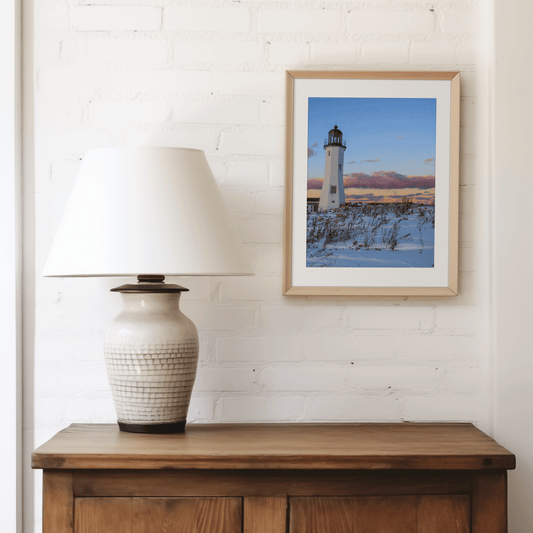 Photo print of Scituate Lighthouse surrounded by snow at sunset place in a living room above a cabinet