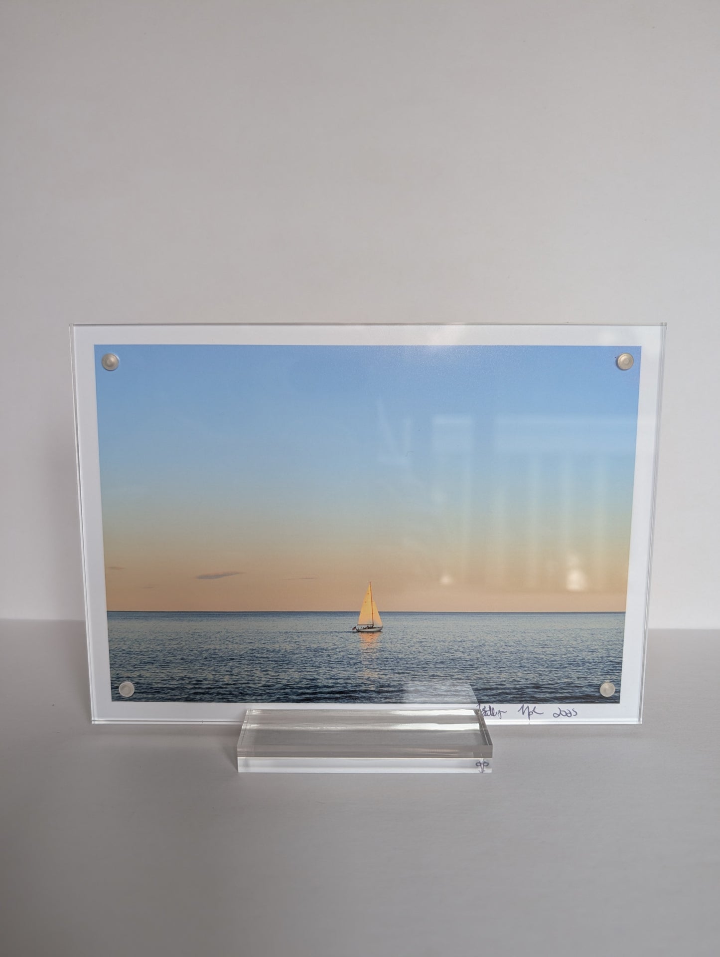 Acrylic block photo print on bookshelf with coastal New England photography