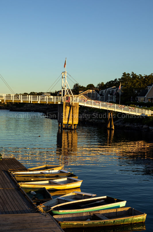 Photograph of rowboats docked in Perkins Cove at sunset in Ogunquit, ME