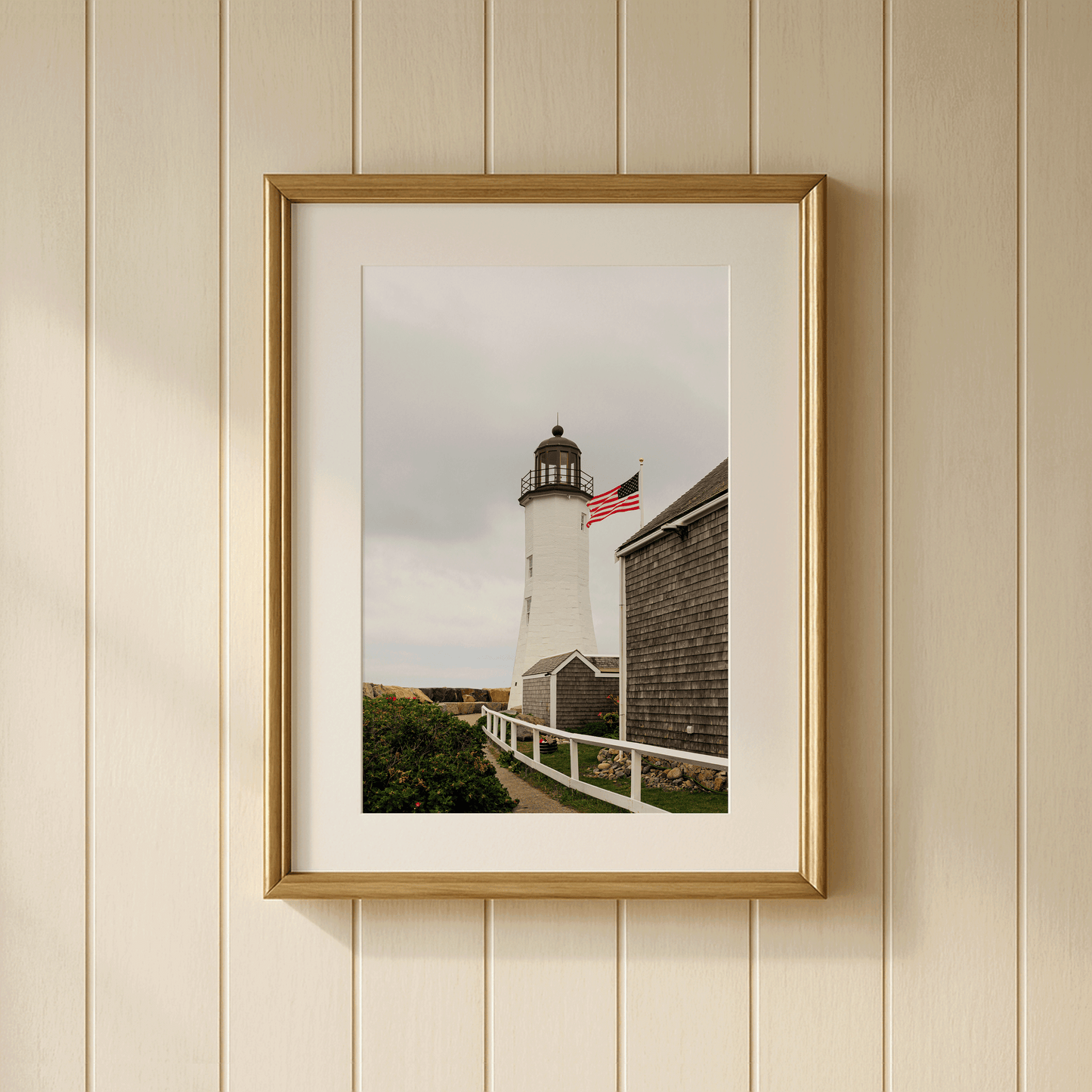 Scituate Lighthouse fine art photography print framed on a wall, Massachusetts South Shore, featuring American flag and warm afternoon light