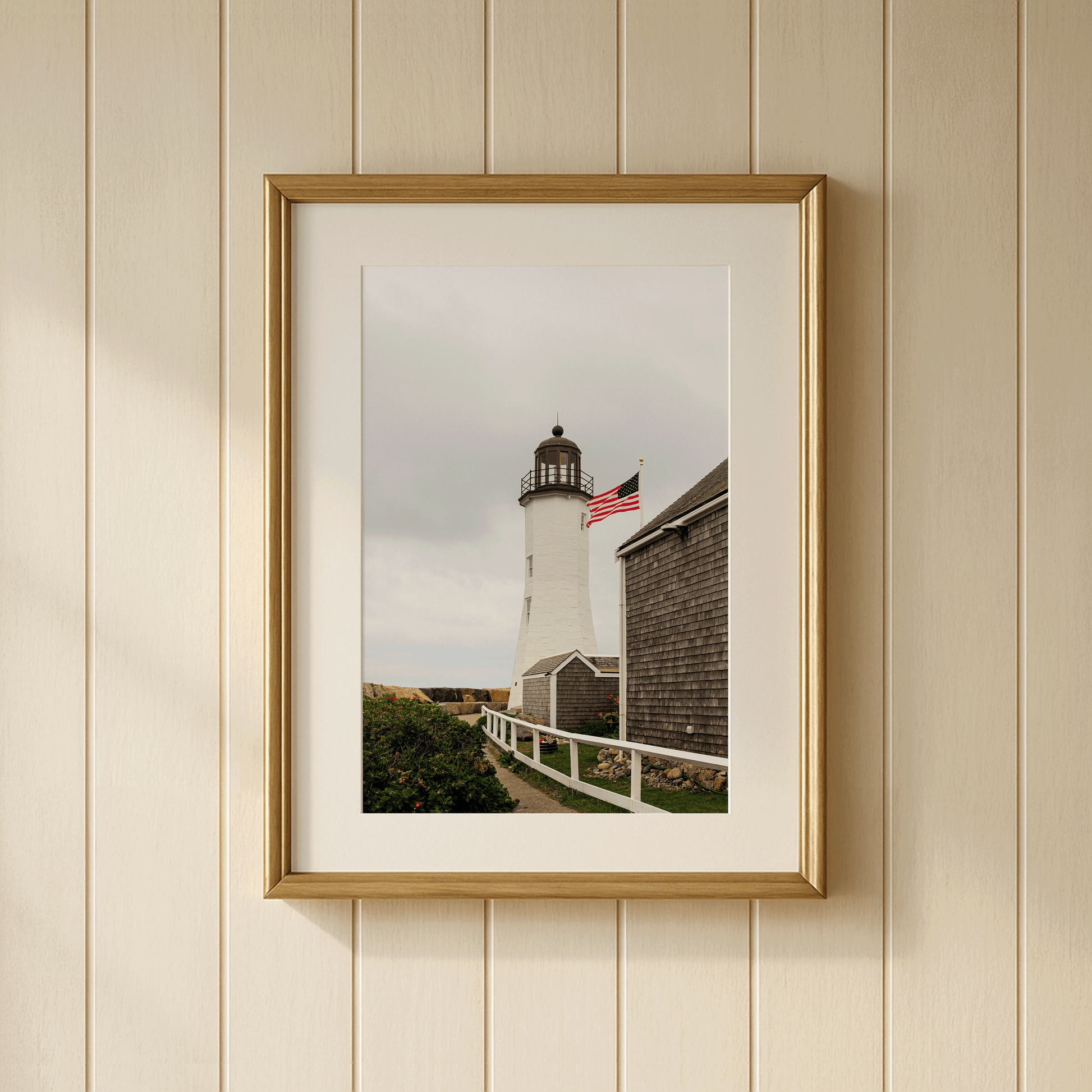 Scituate Lighthouse fine art photography print framed on a wall, Massachusetts South Shore, featuring American flag and warm afternoon light