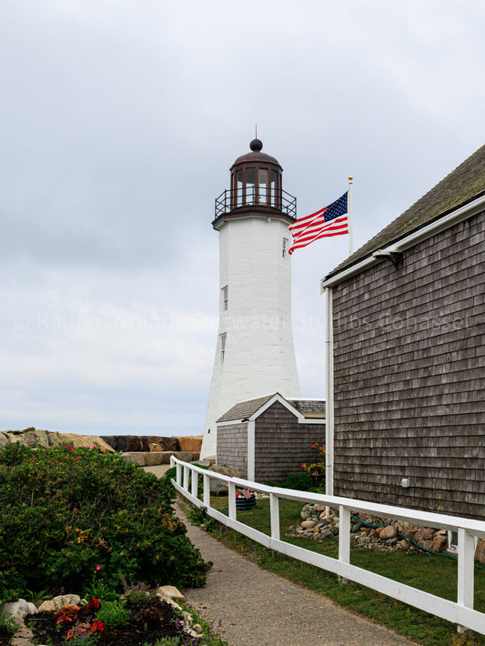 Photograph of Scituate Lighthouse shown on a summer day with an American flag