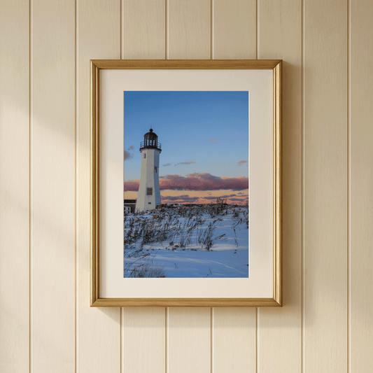 Photo of Scituate Lighthouse at sunset surrounded by snow